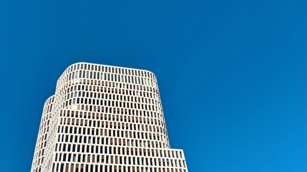 Wochenrueckblick kw 15 2026 die rumgammler - Ein modernes, weißes, mehrstöckiges Gebäude mit einer Fassade aus vielen kleinen, dunklen Fenstern vor einem klaren blauen Himmel.